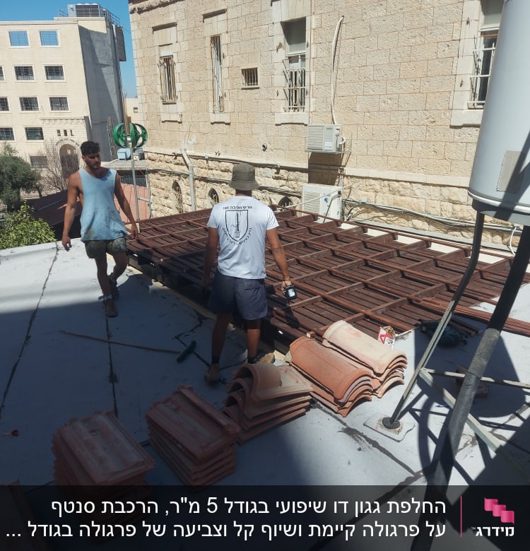 שני אנשים עובדים על גג עם ערימות רעפים